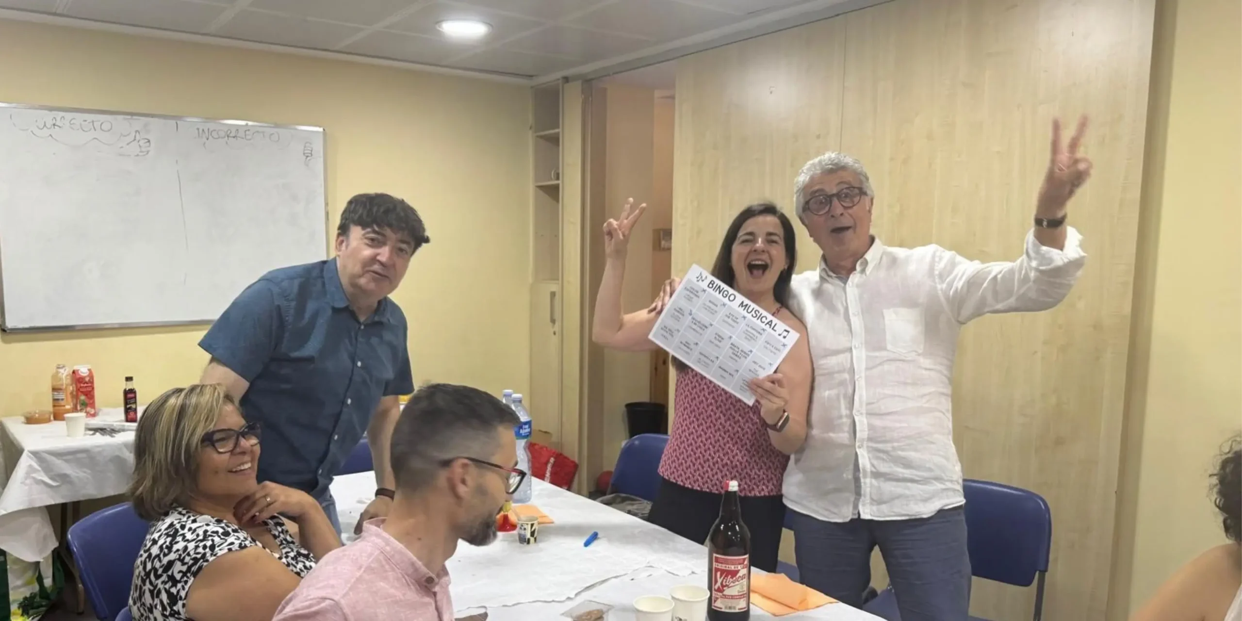 Membres de la comunitat compartint una activitat de bingo musical.
